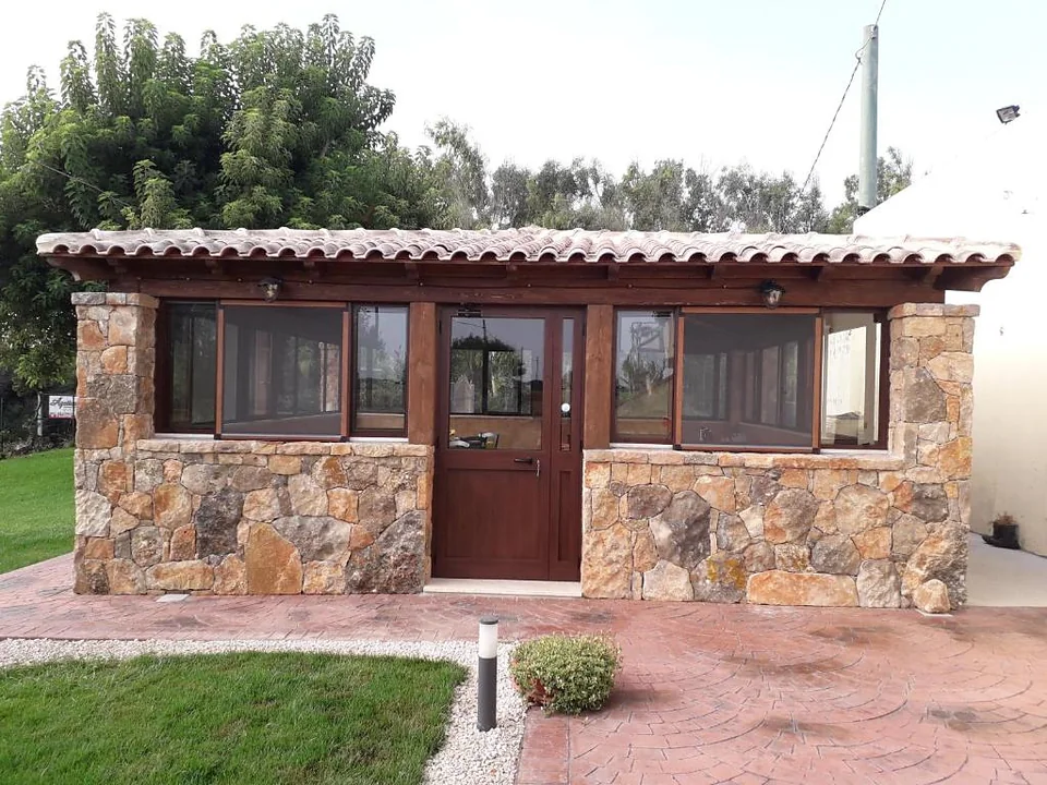 Casetta in pietra con portico e prato curato